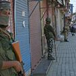 Indian paramilitary troops stand guard in front of closed shops in Srinagar