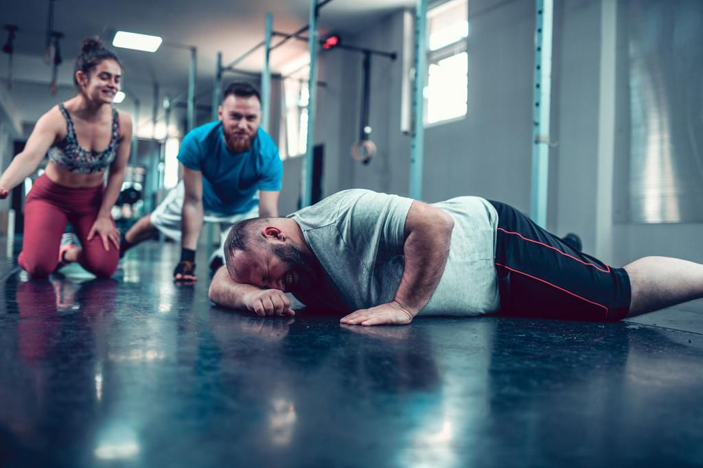 Friends Supporting Overweight Male When He Is About To Give Up Training