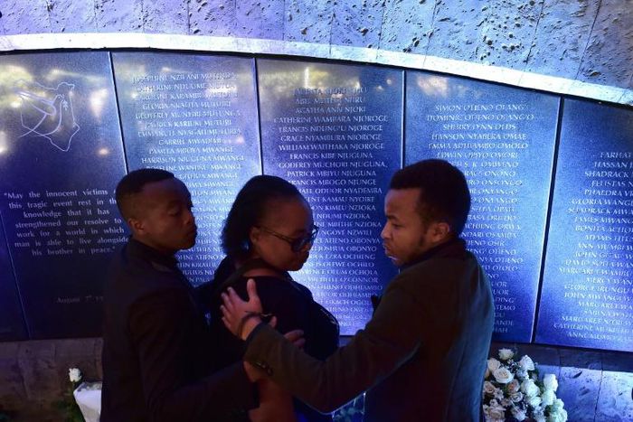 Members of a family who lost a relative, stand next to a plaque bearing the names of those killed in the August 1998 bombing of the US embassy in Nairobi
