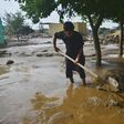 A resident clears mud in Charikar after flash floods killed nearly 50 people