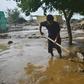 A resident clears mud in Charikar after flash floods killed nearly 50 people