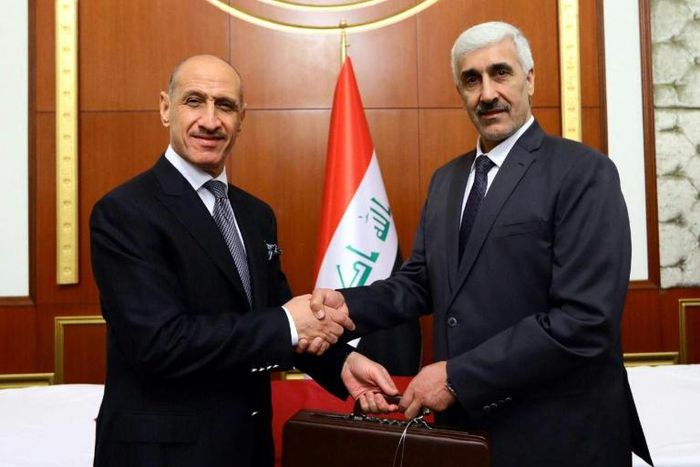 Former Iraqi football star Adnan Dirjal (L) takes the reins as sports minister from his less well-known predecessor Ahmed Ryad