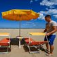 A beach manager spaces out sunbeds on the seafront of Cesenatico on the Adriatic coast