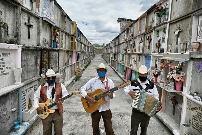 Humberto Montes (C) with musicians Roberto Maldonado (L) and Israel Mundo (R), wait to offer their services before a funeral at the municipal cemetery in Ciudad Nezahualcoyotl on June 3