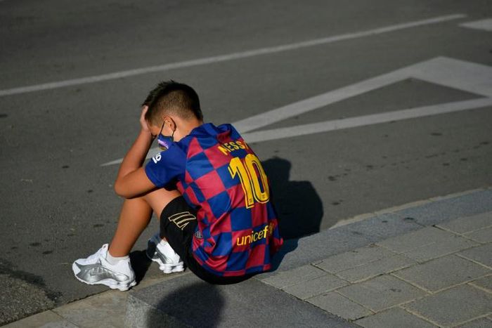 A boy wearing a Lionel Messi shirt waits for the Argentinian to arrive for coronavirus tests at Barcelona's training ground on Sunday.