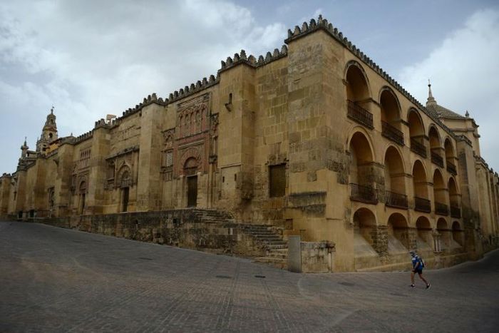 A lone tourist walks around The Mezquita in Cordova, one of Spain's interior cities that is being disproportionately hit by the drop in tourism