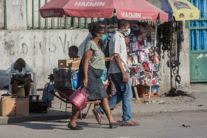 Two people in the Haitian capital Port-au-Prince wear face masks while shopping; a first coronavirus victim has died in Haiti, the government said on April 5, 2020