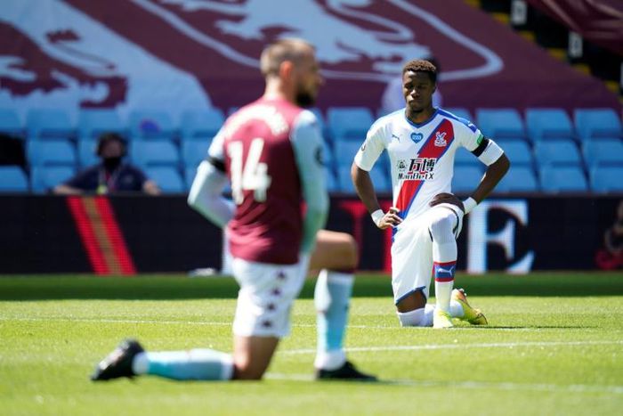 Wilfried Zaha (right)takes a knee prior to Crystal Palace's Premier League match with Aston Villa on Sunday