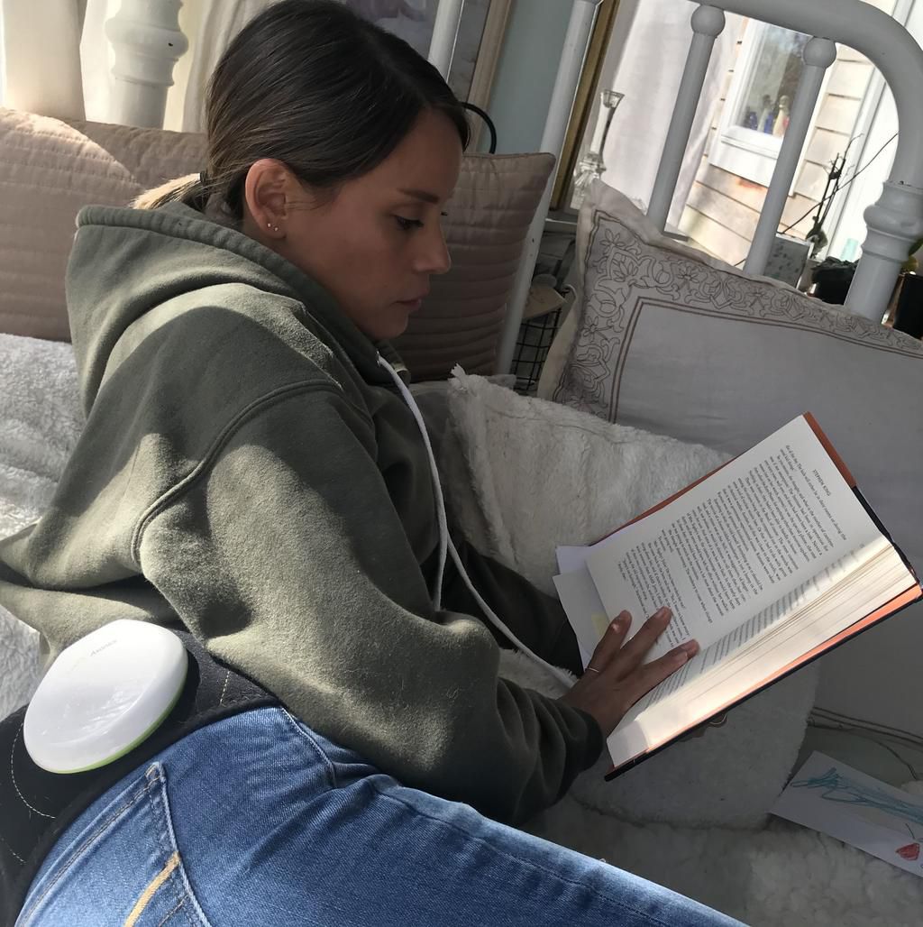 Lori reading while her Axonics system charges.