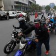 A soldier stands watch in Caracas, Venezuelas as bikers queue up to refuel amid a nationwide shortage