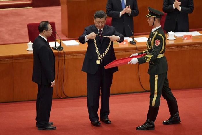 Chinese President Xi Jinping (C) hands a medal to Zhong Nanshan (L) -- the country's most famous medical expert who emerged as the face of China's fight against Covid-19