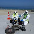 Technicians from Israeli firm Kando extract sewage samples from a manhole near the beach, in the southern coastal Israeli city of Ashkelon