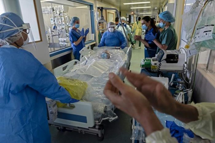 Intensive care workers at Nicosia General Hospital cheer as a coronavirus patient is transferred back to the recovery department on Wednesday