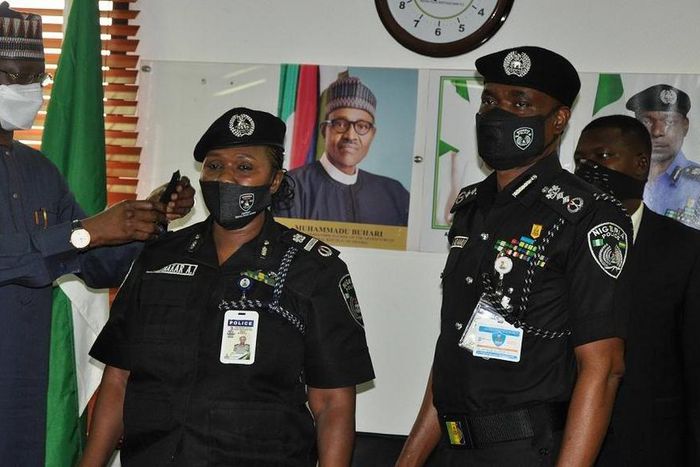 Secretary to the Government of the Federation, Mr Boss Mustapha decorates a newly promoted officer in the presence of Inspector General of Police, Mohammed Adamu on Monday, July 20, 2020. [Twitter/@PoliceNG]
