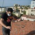 Cuban violinist William Roblejo rehearses on the rooftop of his house in Havana