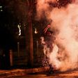 A Lebanese anti-government protester kicks back a tear gas canister fired by security forces during a protest against dire economic conditions in Beirut on Friday night