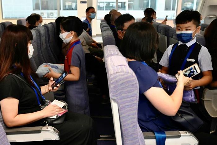 Children act as flight attendants in a mock cabin before a sightseeing 'flight to nowhere' later in the day