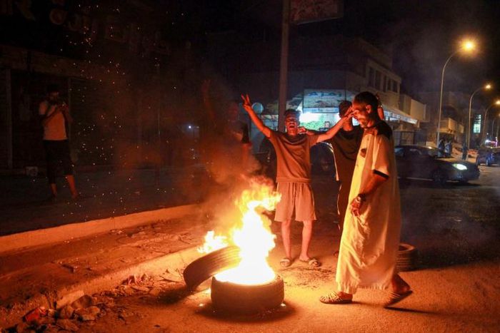 Libyan youth block a road with burning tyres in the eastern city of Benghazi to protest against poor public services and living conditions