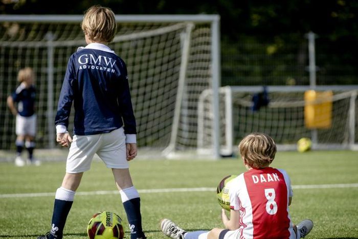 Dutch children play football during the first reopening day of youth training camps in the Netherlands after the coronavirus covid-19 outbreak in The Hague, on April 29, 2020