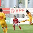 Phan Duc Thong (red shirt) of Pho Hien FC watches as Nguyen Vu Hoang Duong (right) of Thanh Hoa FC plays the ball during their Vietnamese National Football Cup qualifier match at the PVF stadium in Hung Yen in May after football resumed in Vietnam foll...