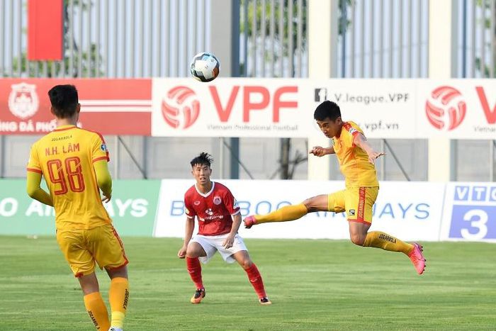 Phan Duc Thong (red shirt) of Pho Hien FC watches as Nguyen Vu Hoang Duong (right) of Thanh Hoa FC plays the ball during their Vietnamese National Football Cup qualifier match at the PVF stadium in Hung Yen in May after football resumed in Vietnam foll...