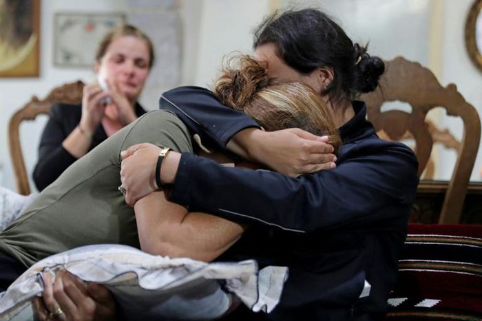 (L to R) Rita Hitti (mother of 27-year-old missing fireman Najib) and her daughter Carlyn (wife of 37-year-old missing fireman Charbel Karam) cry as they comfort each other at their home in the mountain town of Qartaba, north of the Lebanese capital
