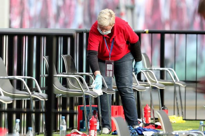 A member of staff cleans the substitute bench during half time of RB Leipzig's draw with Hertha Berlin