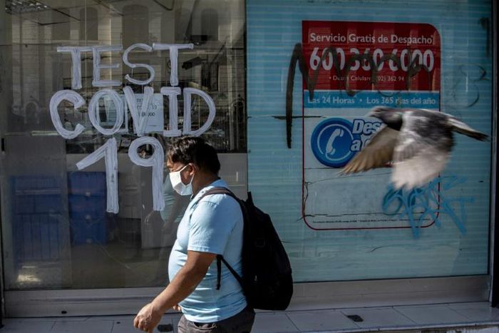 A man walks past a pharmacy where COVID-19 tests are conducted in  Santiago, Chile