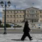 A woman wearing a face mask walks past the empty Syntagma Square in Athens, in front of the Greek Parliament early during the outbreak of COVID-91.