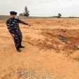 A member of security forces affiliated with the GNA's Interior Ministry surveyed the reported site of a mass grave in the town of Tarhuna, southeast of the capital Tripoli