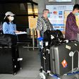 A worker sprays sprays hand sanitizer onto passengers arriving in March 2020 at Taoyuan Airport in Taiwan, one of the few places for which the United States has completely lifted its warning to avoid travel due to the coronavirus