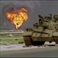 An abandoned Iraqi Soviet-made T-62 tank sits in the Kuwaiti desert as an oil well burns in the background, on April 2, 1991