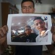 Anass Tahiri, 22, holds a picture of him and his brother, Iliass, who died while being restrained in a juvenile detention centre in Spain