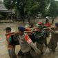 Rescuers carry a body recovered after flash floods in South Sulawesi which killed at least 15 people