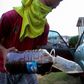 A youngster fills a car with gasoline purchased on the streets in Maracaibo, Venezuela, in August 2020