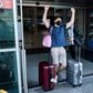 A traveller, mask-clad due to the COVID-19 coronavirus pandemic, arriving on one of the first flights from Britain gestures as he walks with luggage out of the terminal at Cyprus' Larnaca International Airport on August 1
