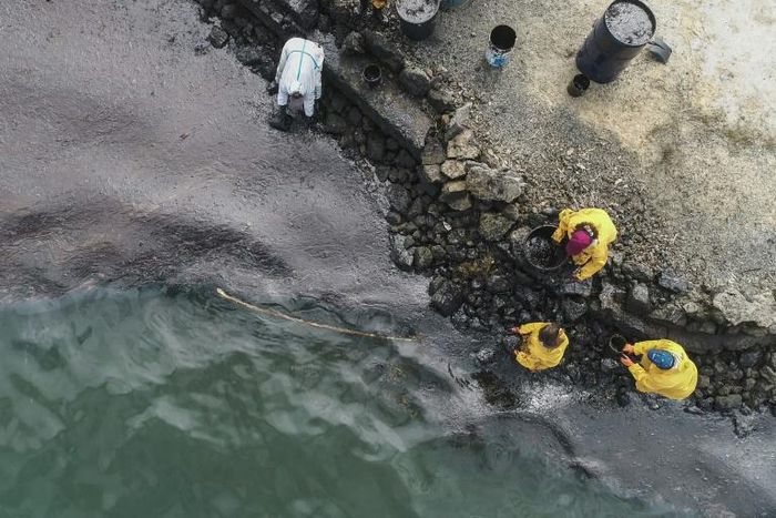 All-hands emergency: People scoop up oil at Bambous Virieux beach