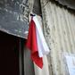 A woman hangs colored flags on the door of her house to signal she needs to be delivered food (white) and medicine (red) for her sick husband, at La Brigada neighbourhood in Guatemala City