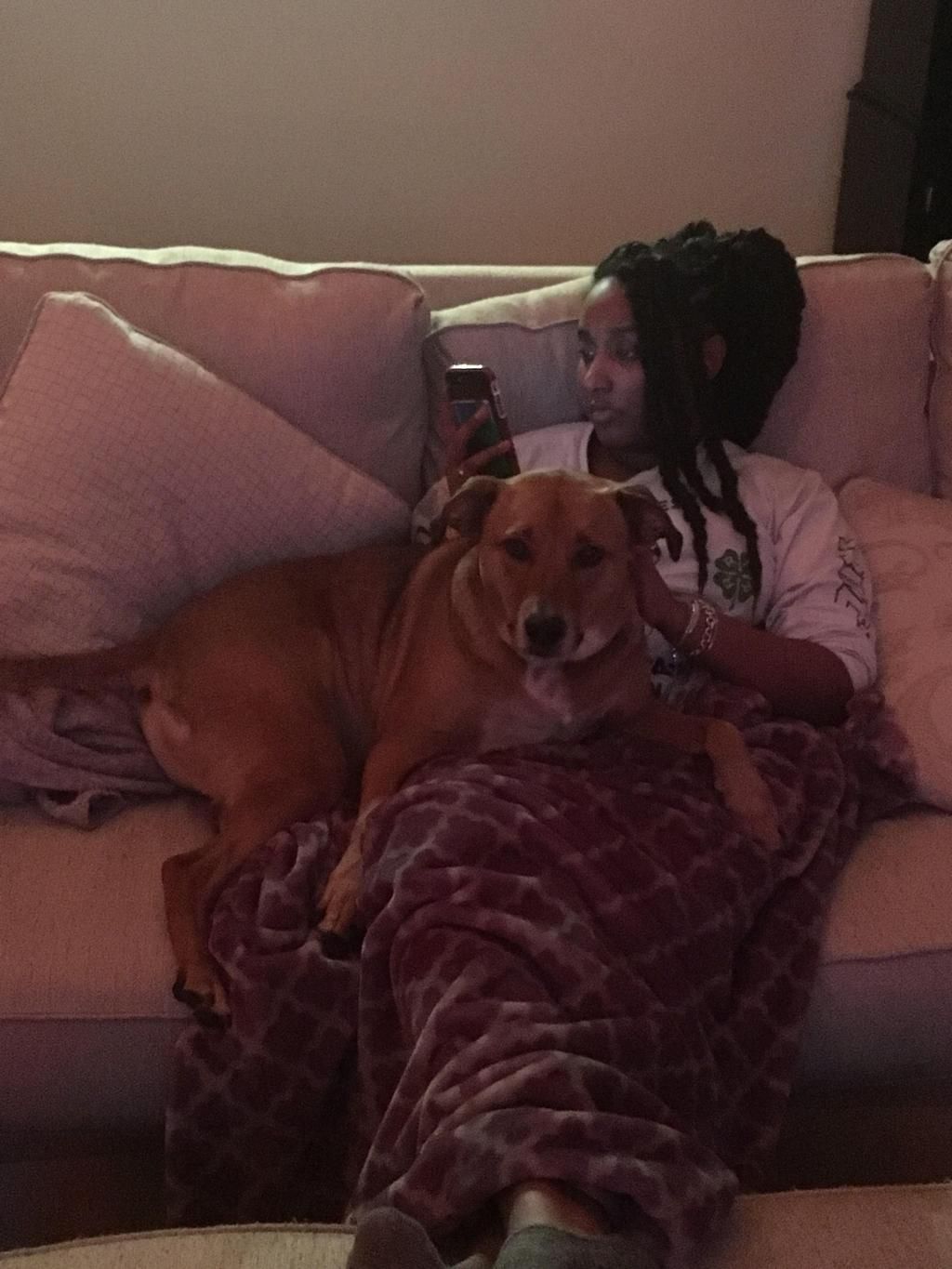 Paige decompressing on the couch with her familys dog.