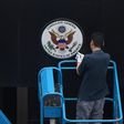 A worker removes the Great Seal of the United States from the front of the US consulate in the Chinese city of Chengdu