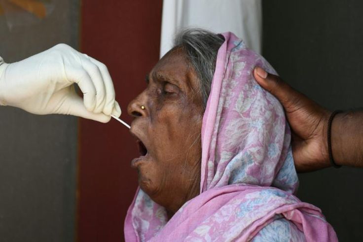 A woman is tested for coronavirus in New Delhi. Cases are soaring in the world's second most populous nation