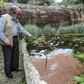 Botanist Alberto Gomez cleans a lake at his botanical garden in Quindio, Colombia