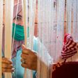 A Moroccan rug weaver peeks from behind carpet thread at a workshop in the city of Sale, north of the capital Rabat