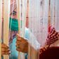 A Moroccan rug weaver peeks from behind carpet thread at a workshop in the city of Sale, north of the capital Rabat