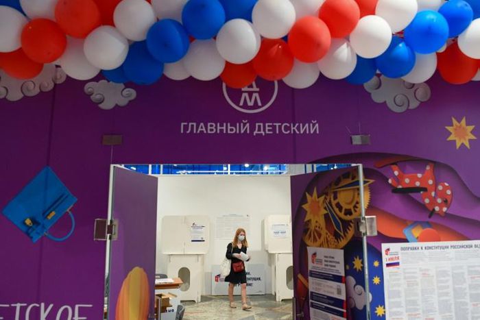 A woman wearing a face mask and gloves against the spread of coronavirus goes to cast her ballot on constitutional reforms which could see President Putin stay in power until 2036
