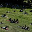 People enjoy the sun in a Paris park, but experts fear a surge in coronavirus infections