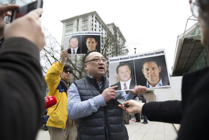 An activist in Vancouver on March 6, 2019 holds photos of Canadians Michael Spavor and Michael Kovrig, who are detained by China, outside British Columbia Supreme Court where Huawei executive Meng Wanzhou appeared