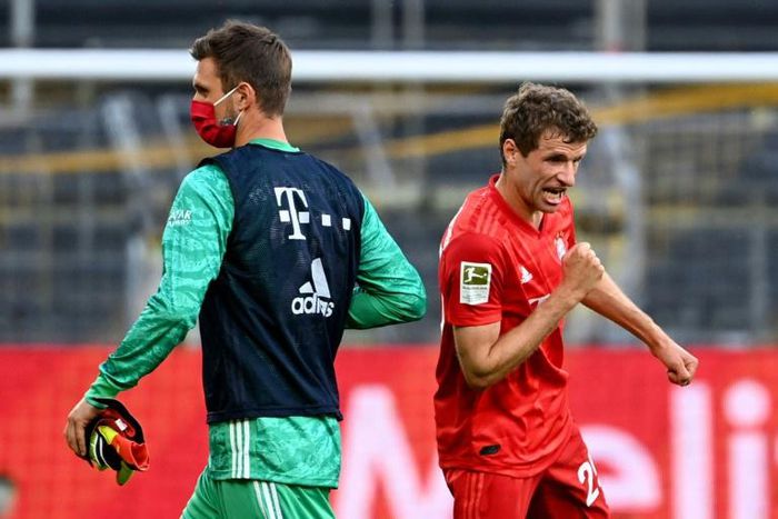 Bayern Munich's Thomas Mueller elbow bumps substitute goalkeeper Sven Ulreich after the Borussia Dortmund win