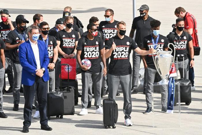 Bavaria's State Premier Markus Soeder (L) welcomes Bayern Munich's players after the Champions League win