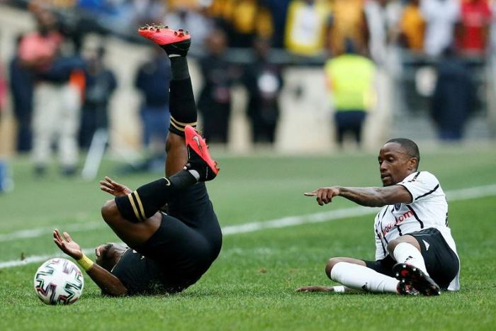 George Maluleka (L) of Kaizer Chiefs tumbles after colliding with Mthokozisi Dube (R) of Orlando Pirates in a match between the biggest South African Premiership crowd-pullers